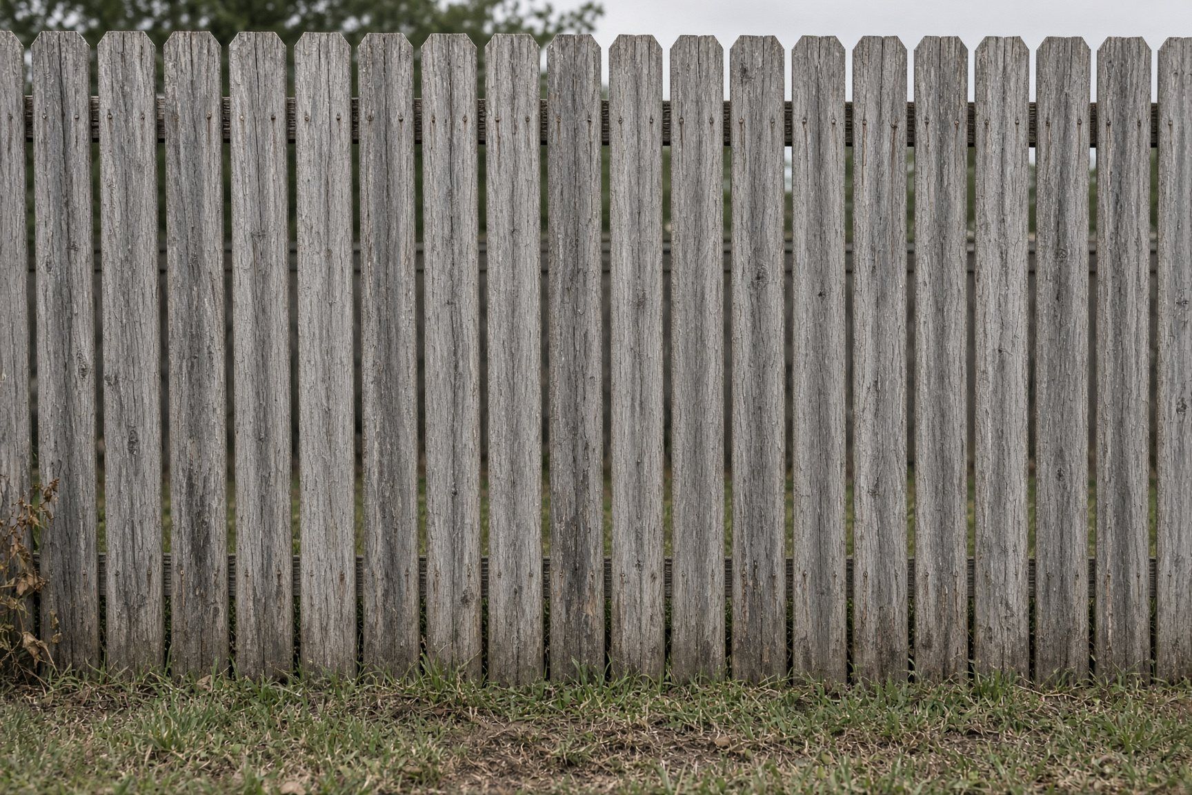 Weathered gray Oklahoma privacy fence before revival